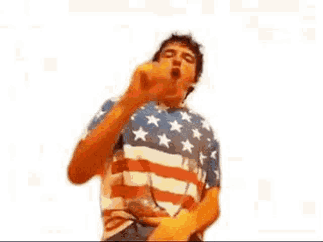 a man in an american flag shirt is dancing and covering his face with his hand .