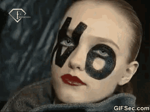 a close up of a woman 's face with the number 66 painted on her face .