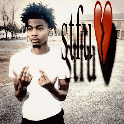 a man in a white shirt stands in front of a broken heart with the word stiff written in black spray paint