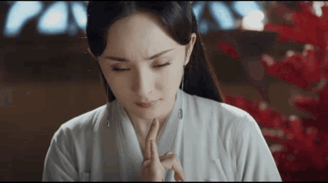 a woman in a white dress is making a face