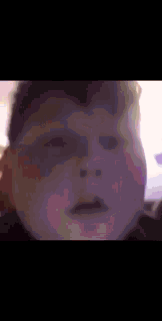 a close up of a person 's face with a blurred image