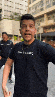 a man wearing a black shirt that says jesus e o dono on it
