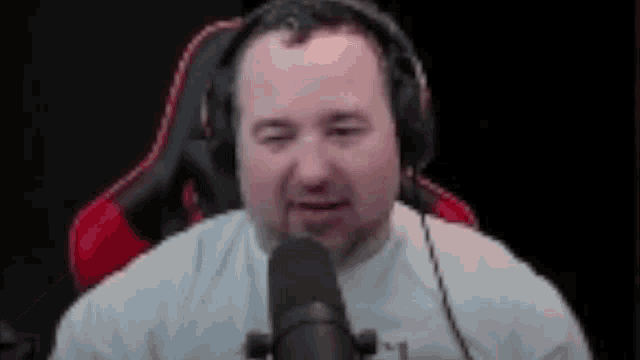 a man is wearing headphones and talking into a microphone .