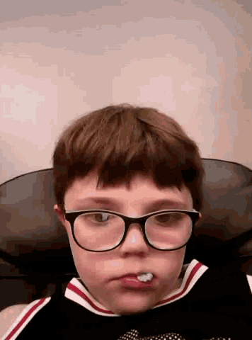 a young boy wearing glasses is making a face