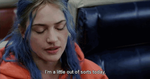 a woman with blue hair is sitting in a chair and says i 'm a little out of sorts today .