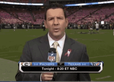 a man in a suit and tie is holding a microphone in front of an nfl stadium