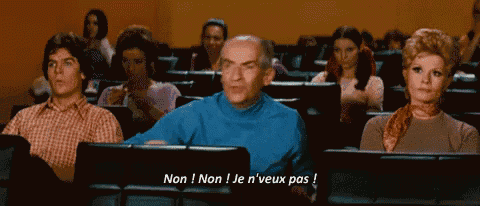 a group of people are sitting in a lecture hall and one of them is saying non ! non i je n'veux pas