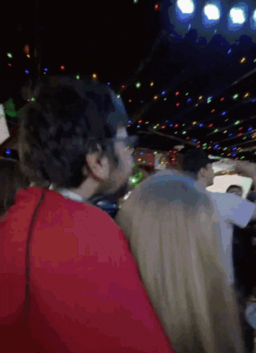 a man in a red shirt is standing next to a woman in a crowd