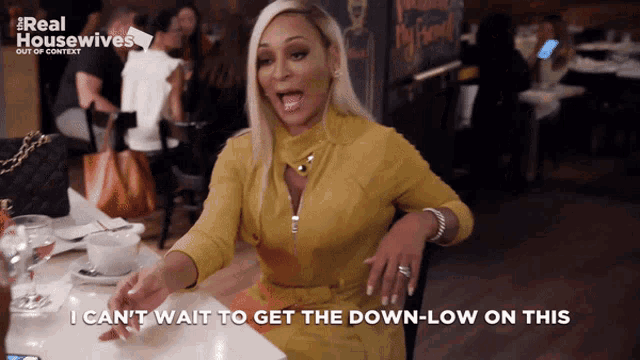 a woman sitting at a table with a sign that says real housewives