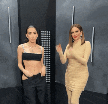 two women are standing next to each other and one is wearing a black top