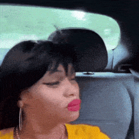 a woman with red lips is sitting in the back seat of a car
