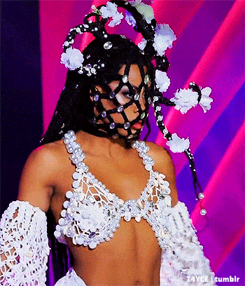 a woman is wearing a bra and gloves with flowers on her head
