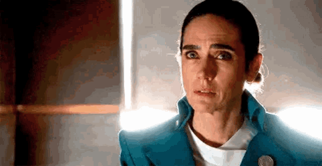 a close up of a woman 's face with a blue jacket on .