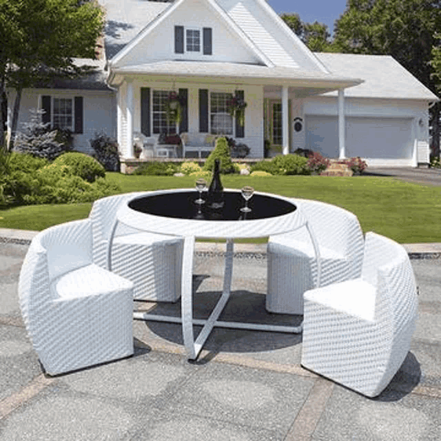 a white table and chairs are in front of a white house