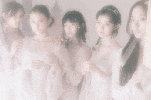 a group of young girls are standing next to each other in a foggy room
