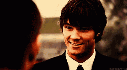 a man in a suit and tie is smiling and praytocastiel is written below him