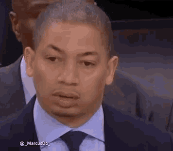 a man in a suit and tie is looking at the camera .