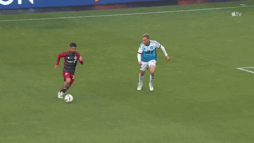 a soccer player wearing a number 17 jersey dives to catch the ball
