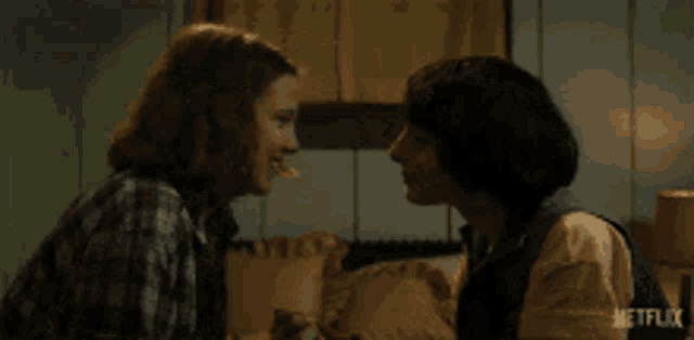 a man and a woman are looking at each other while sitting on a couch .