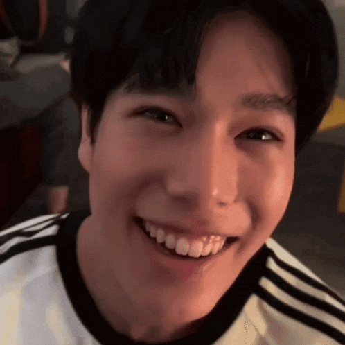 a close up of a young man 's face smiling