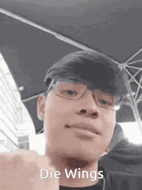 a young man wearing glasses and a hat with the words die wings written on his face