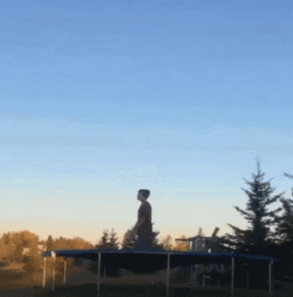 a person is jumping on a blue trampoline with a blue sky in the background