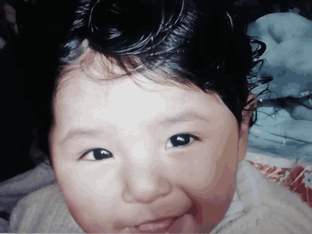 a close up of a baby 's face with a sweater on