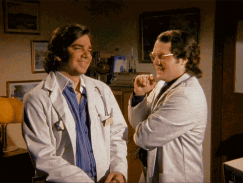 two doctors in white coats are talking to each other