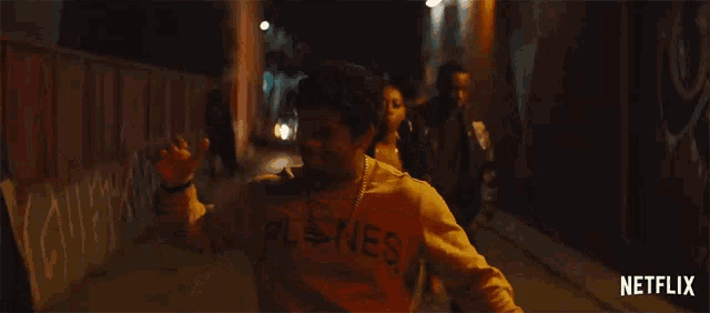 a group of people are walking down a street at night with a netflix logo on the bottom