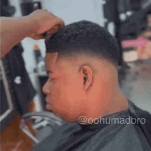 a man is getting his hair cut by a barber with the hashtag @oohumadbre