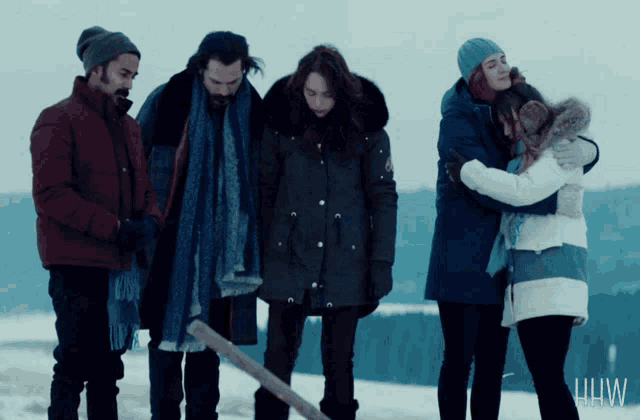 a group of people are standing in the snow with the letters hw on the bottom