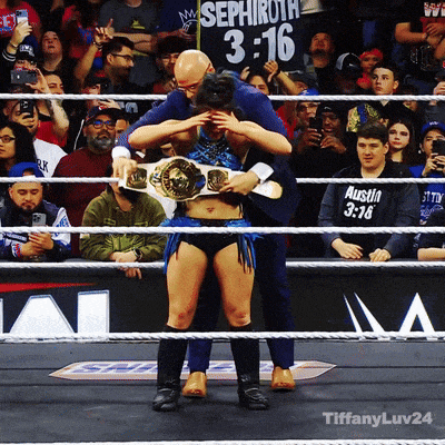 a man holds a woman in a wrestling ring with a sign behind him that says sephiroth 3:16