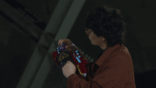 a man in a brown jacket is holding a can that says ' energy drink ' on it