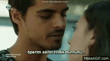 a man and a woman are kissing and the man is saying `` operam senin idik burnunu '' .