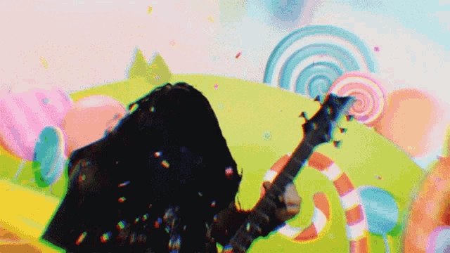 a person playing a guitar in front of a candy background