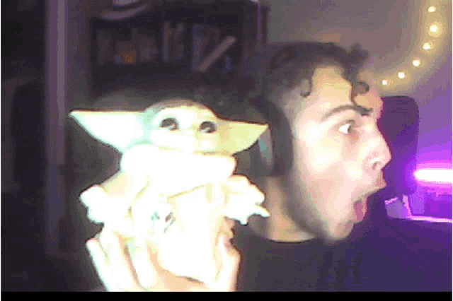 a man wearing headphones holds a stuffed animal in front of his face