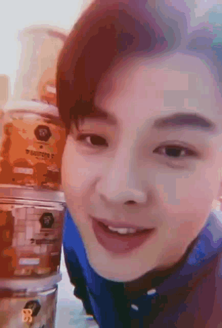 a close up of a man 's face with a stack of containers behind him .