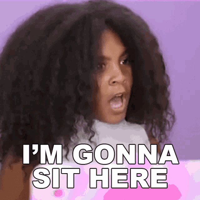a little girl with curly hair is making a funny face and saying i 'm gonna sit here .