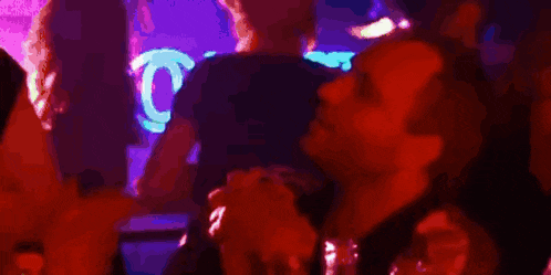 a blurry picture of people in a dark room with a red light behind them