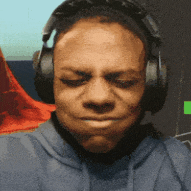 a man wearing headphones is making a face with his eyes closed