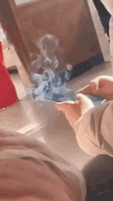 Pessoa usando um celular saindo fumaça.