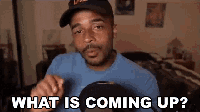 a man wearing a hat and a blue shirt is asking what is coming up