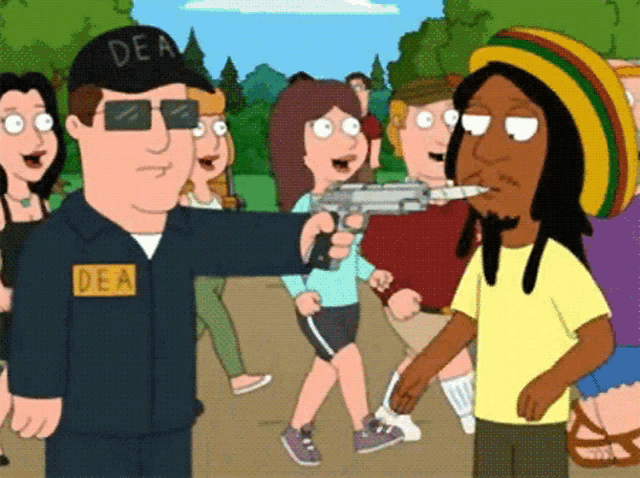a man in a dea uniform holds a gun in front of a group of people