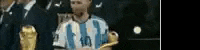 a man in a striped shirt is holding a trophy in his hand .