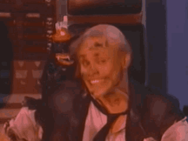 a man in a leather vest and tie is laughing