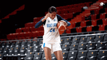 a female basketball player wearing a white jersey with the number 24 on it