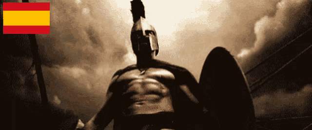 a statue of a spartan warrior with the spanish flag behind him
