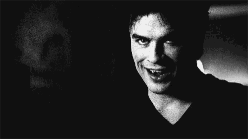 a black and white photo of a man with his tongue out and a ghost behind him