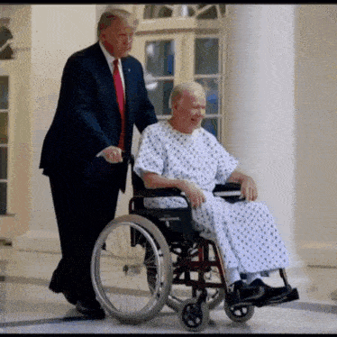 a man in a suit and tie is pushing an elderly man in a wheelchair