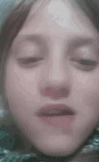 a close up of a girl 's face with her eyes closed and her mouth open